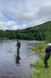 James Robertson landing a grilse in big water
